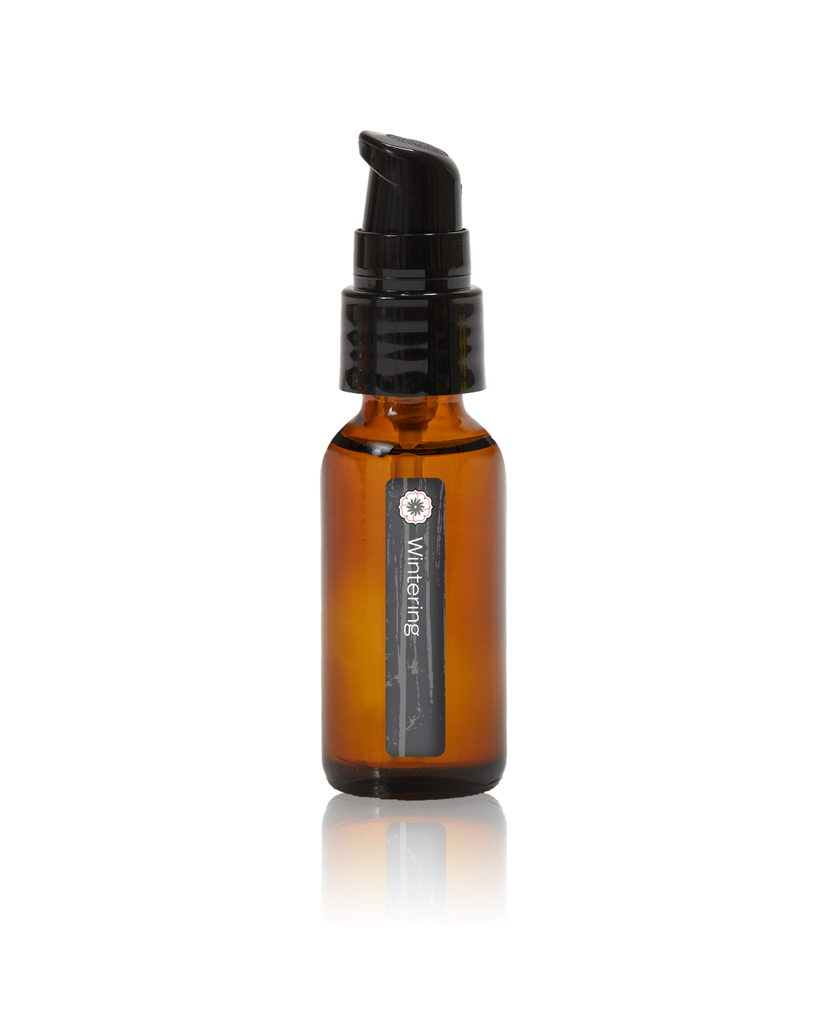An amber glass bottle of Wintering oil by BodyMantra, featuring a minimalist label and set against a seamless neutral background.